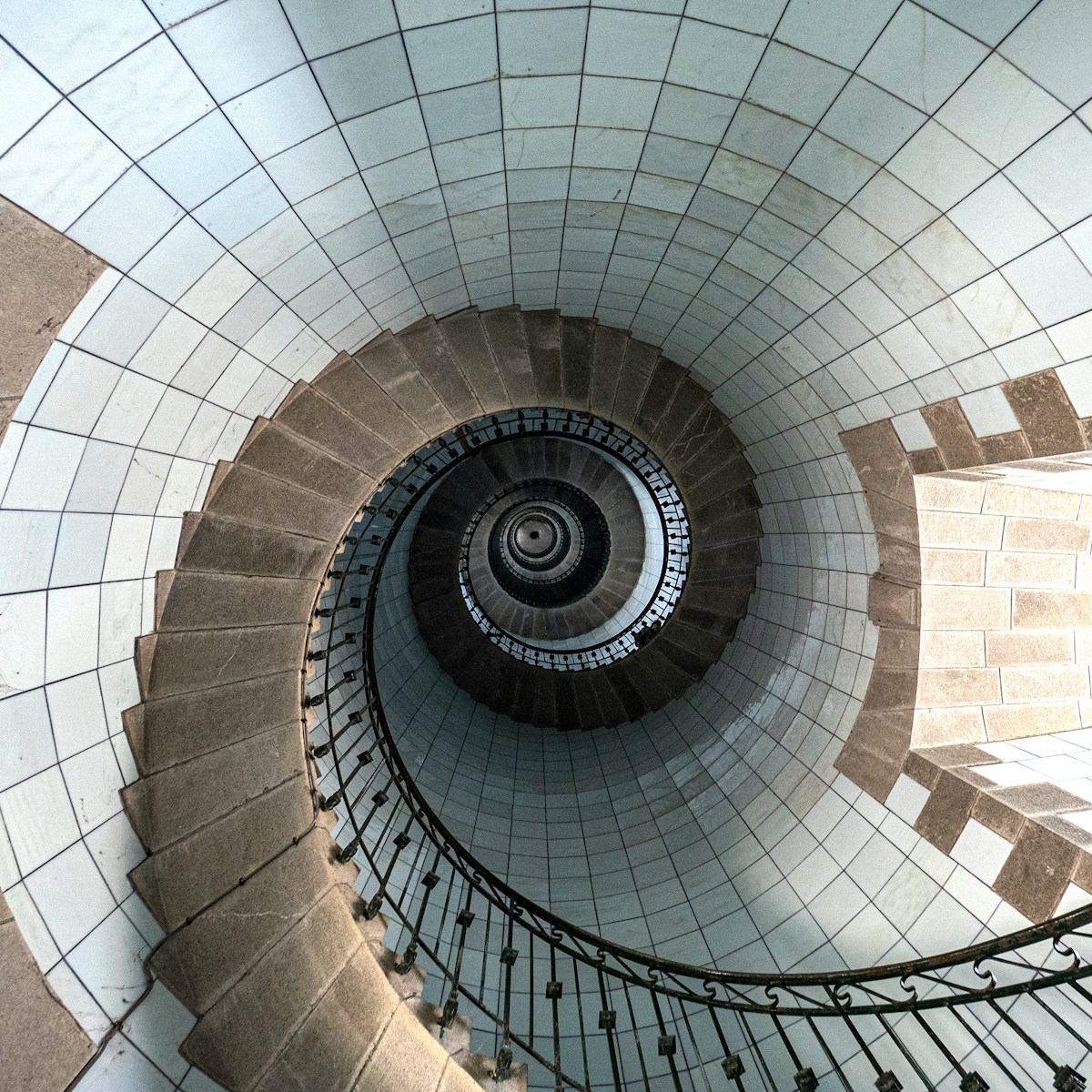a spiral staircase in a building with tiled walls